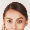 Close-up of a woman's face focusing on her well-groomed brows and brown eyes.