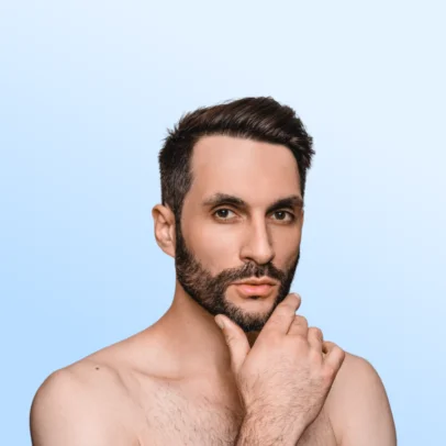 Close-up portrait of a shirtless man with a beard, touching his chin and looking at the camera against a soft blue gradient background.