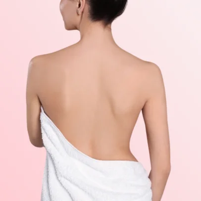 Back view of a woman with bare shoulders and a white towel wrapped around her waist against a pink gradient background.