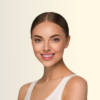 Smiling young woman with dark hair pulled back, wearing a white tank top, against a pale beige background.
