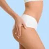 Close-up of a woman's midsection in white underwear, hand resting on her hip against a pale blue background.